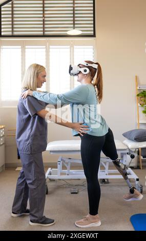 Femme dans la jambe prothétique utilisant le casque VR avec thérapeute pour la formation de l'équilibre Banque D'Images