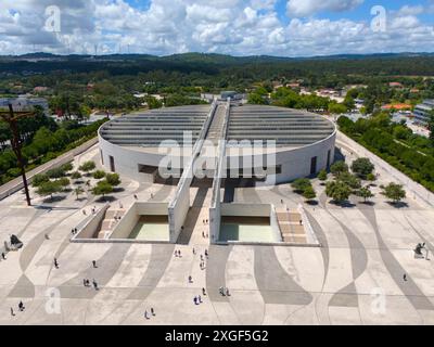 Architecture moderne avec une grande place et des gens, entouré d'arbres et de forêts, sous un ciel nuageux, vue aérienne, Basilique du très Saint Banque D'Images