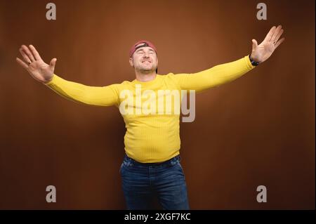 Un homme d'âge moyen, originaire du Caucase, dansait en studio sur fond marron. Portrait de studio Banque D'Images