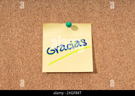 Merci mot en espagnol sur note jaune sur liège carte Banque D'Images