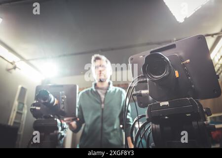 Un caméraman masculin utilise une caméra de cinéma dans un téléviseur studio d'enregistrement Banque D'Images