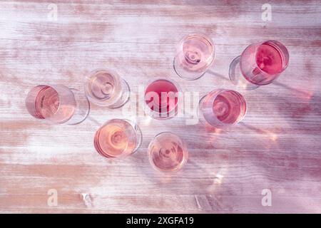 Types de vin rose, tiré d'en haut, tonifié en rose, de nombreux verres de vin sur une table en bois Banque D'Images