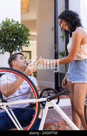 Fixation du vélo, jeune couple griller avec des boissons, profiter du temps en plein air ensemble Banque D'Images