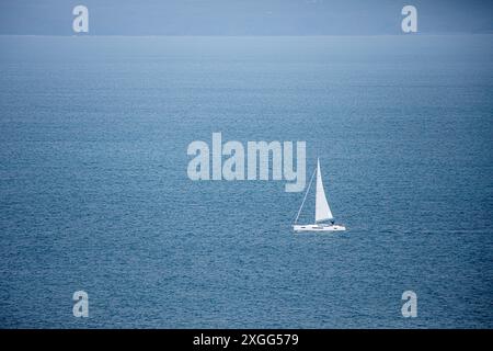 Bateau à voile solitaire / yacht sur une mer bleue calme Banque D'Images