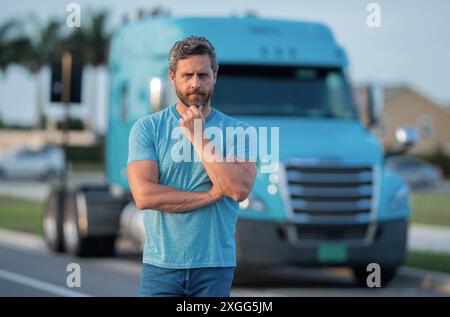 Conducteur homme près d'un camion. Homme propriétaire camion . Propriétaire sérieux d'un camion d'âge moyen. Véhicules de l'industrie du transport. Beau conducteur Banque D'Images