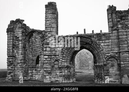 Photo en noir et blanc d'anciennes ruines de pierre avec des arcades et des murs altérés, sur fond brumeux, Royaume-Uni, Europe Banque D'Images