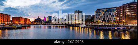 Vue panoramique au crépuscule du Royal Albert Dock illuminé et de l'horizon moderne du front de mer de Liverpool reflétant Salthouse Dock, Merseyside, Royaume-Uni Banque D'Images