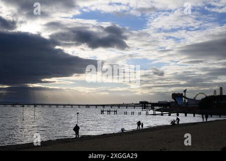 16 février 2024 : les amateurs de plage sur Southend-on-Sea Beach se silhouettent contre le soleil de fin d'après-midi. Banque D'Images