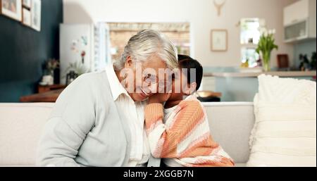 Secret, enfant et grand-mère dans le salon, à la maison et murmure pour une blague drôle dans l'oreille. Collage, canapé et salon de maison familiale avec fille et femelle Banque D'Images