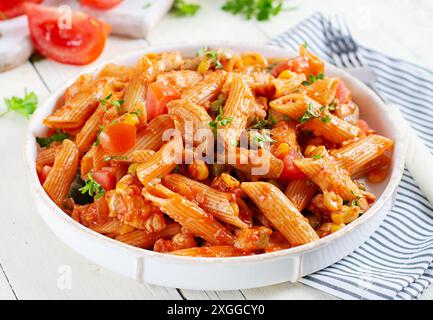 Pâtes italiennes classiques penne arrabbiata avec légumes sur table en bois blanc. Pâtes Penne à la sauce arrabbiata. Banque D'Images