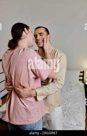 Un jeune couple gay s’embrasse dans leur appartement moderne, rayonnant d’amour et de bonheur. Banque D'Images