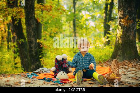 Amitié d'enfance et premiers souvenirs. Camping avec enfants. Petit garçon en pull ou pull bleu vintage tendance. Banque D'Images