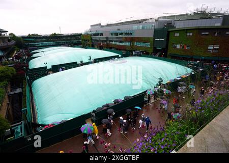 Une vue générale des courts extérieurs couverts alors que la pluie tombe le neuvième jour des championnats de Wimbledon 2024 au All England Lawn Tennis and Croquet Club, Londres. Date de la photo : mardi 9 juillet 2024. Banque D'Images