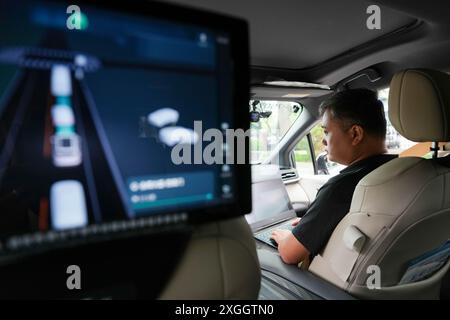 (240709) -- BEIJING, 9 juillet 2024 (Xinhua) -- Wang Wei effectue des essais routiers pour un véhicule autonome dans une zone de démonstration de conduite autonome à Yizhuang à Beijing, capitale de la Chine, le 19 juin 2024. Wang Wei a rejoint Pony.ai, un fournisseur chinois de solutions de conduite autonome en 2019 et travaille maintenant comme superviseur de la sécurité des véhicules autonomes. Il est responsable de la maintenance des dispositifs qui soutiennent les opérations sans conducteur et de la modification du matériel et des logiciels des voitures autonomes. Le secteur chinois de la conduite autonome est en pleine expansion avec une expansion robuste des essais routiers qui balayent le pays. Ceci Banque D'Images