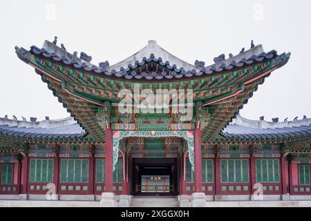 Entrée du palais coréen ornée avec des peintures vertes et rouges éclatantes, mettant en valeur une architecture traditionnelle complexe Banque D'Images