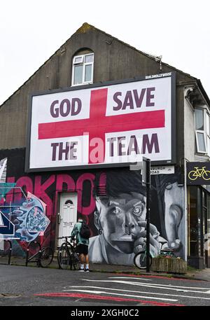 Brighton Royaume-Uni 9 juillet 2024 - Un panneau géant God Save the Team par l'artiste Corbyn Shaw juste à côté de Lewes Road à Brighton la veille de l'affrontement de l'Angleterre contre les pays-Bas dans leur match de demi-finale à l'Euro 2024 en Allemagne . Il fait partie de Buildhollywood qui se spécialise dans l'art créatif de la publicité de rue dans les villes britanniques : crédit Simon Dack / Alamy Live News Banque D'Images