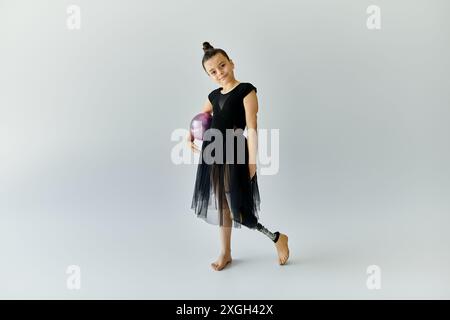 Une jeune fille avec une jambe prothétique pratique la gymnastique dans un studio. Banque D'Images