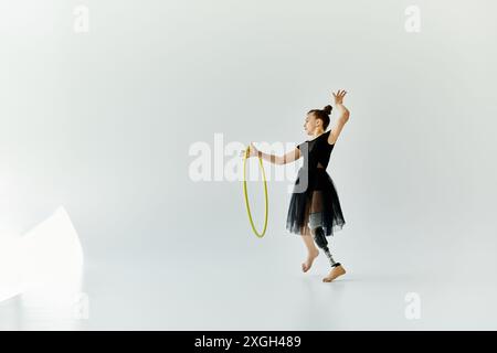 Un jeune gymnaste avec une jambe prothétique effectue une routine gracieuse avec un cerceau. Banque D'Images