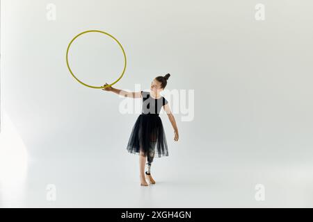 Une jeune fille avec une jambe prothétique pratique la gymnastique avec un cerceau. Banque D'Images