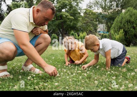 Père et enfants jouant dans le parc pendant l'été Banque D'Images