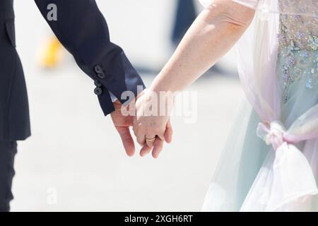 Gros plan d'un couple tenant la main, symbolisant l'amour et l'unité le jour de leur mariage Banque D'Images
