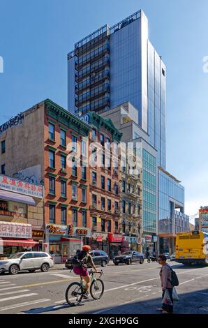 NYC Chinatown : vieux appartements en briques et nouvelle tour de verre sur East Broadway, regardant à l'est de Forsyth Street par un matin de semaine tranquille en juin. Banque D'Images