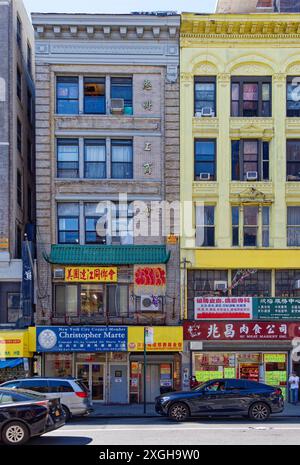 NYC Chinatown : 65 East Broadway, un bâtiment commercial en brique de cinq étages fait « chinois » en ajoutant une corniche de tuiles vertes au-dessus du deuxième étage. Banque D'Images