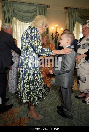 La reine Camilla rencontre Jayden Lowndes, championne de l'alphabétisation de 10 ans, de Stoke-on-Trent, alors qu'elle accueille des bénévoles et des auteurs communautaires à Clarence House, au centre de Londres, pour célébrer le 30e anniversaire de l'organisme de bienfaisance du National Literacy Trust. Date de la photo : mardi 9 juillet 2024. Banque D'Images