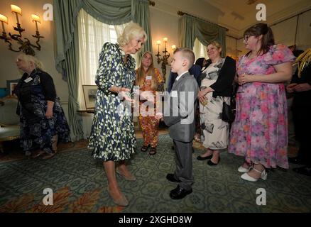 La reine Camilla rencontre Jayden Lowndes, championne de l'alphabétisation de 10 ans, de Stoke-on-Trent, alors qu'elle accueille des bénévoles et des auteurs communautaires à Clarence House, au centre de Londres, pour célébrer le 30e anniversaire de l'organisme de bienfaisance du National Literacy Trust. Date de la photo : mardi 9 juillet 2024. Banque D'Images