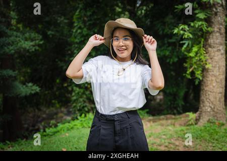 Asiatique jeune belle femme Backpacker voyageant seul dans la forêt sauvage. Attrayant voyageur de fille regarder autour et explorer tout en marchant dans l'esprit de bois de la nature Banque D'Images