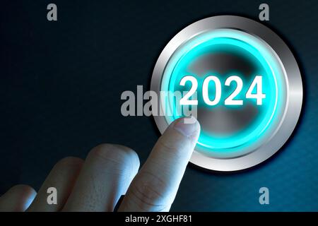 Bonne année 2024, doigt sur le point de tordre le bouton de démarrage 2024. Concept de planification et nouveau départ Banque D'Images