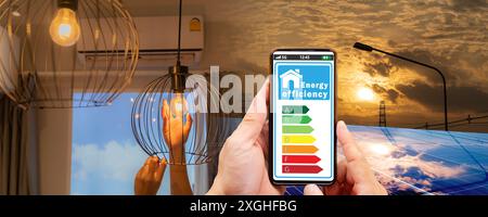 Panneau solaire avec système photovoltaïque. Maison de technologie des énergies renouvelables. La main d'une femme change une ampoule. Ampoules à incandescence spiralées. meilleur ener Banque D'Images