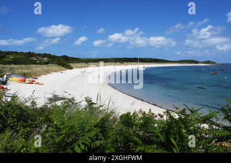 Le sable blanc de la plage par en dessous de Higher Town sur l'île de St Martin dans l'archipel des îles Scilly. Paix et tranquillité avec bleu clair Banque D'Images