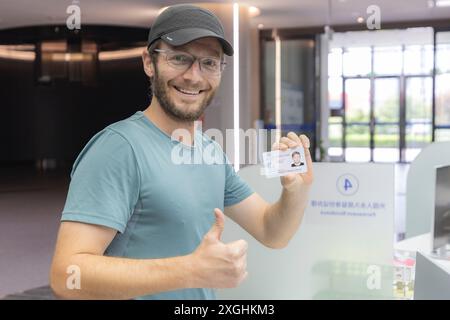 (240709) -- CHONGQING, 9 juillet 2024 (Xinhua) -- Un étranger montre sa carte d'identité de résident permanent étranger au département de l'administration des entrées-sorties du Bureau municipal de la sécurité publique de Chongqing dans le sud-ouest de la Chine, Chongqing, 9 juillet 2024. Chongqing a traité plus de 150 000 passagers étrangers entrants et sortants au cours du premier semestre de cette année, soit 4,9 fois plus qu’à la même période l’an dernier. Avec des politiques de visa optimisées, Chongqing continue d'améliorer la gestion des itinéraires pour les groupes de voyage entrants, offrant aux voyageurs étrangers des choix plus flexibles sur les ports d'entrée et de sortie. Meanwh Banque D'Images