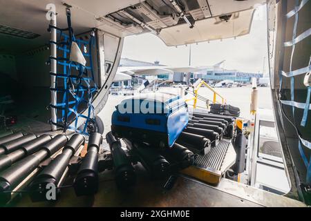 Chargement des bagages dans l'avion à l'aéroport. Valises sur bande transporteuse à l'espace de chargement dans l'avion. Banque D'Images