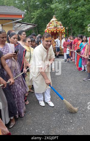 Avant le début du Ratha Yatra 2024, un dévot hindou balaie le chemin que le char traversera pendant la procession. À Wilton Connecticut. Banque D'Images