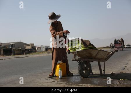 Kaboul, Afghanistan. 9 juillet 2024. Un enfant afghan vend du concombre à Kaboul, Afghanistan, le 9 juillet 2024. Plus de 24 pour cent des enfants afghans âgés de 5 à 17 ans éprouvent de l'anxiété dans ce pays ravagé par la guerre, a indiqué un rapport publié lundi par le Fonds international d'urgence pour l'enfance (UNICEF) des Nations Unies. POUR ALLER AVEC 'plus de 24 % d'enfants afghans éprouvent de l'anxiété : UNICEF' crédit : Saifurahman Safi/Xinhua/Alamy Live News Banque D'Images