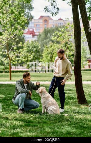 Un couple gay profite d’un après-midi ensoleillé dans le parc avec leur labrador retriever. Banque D'Images