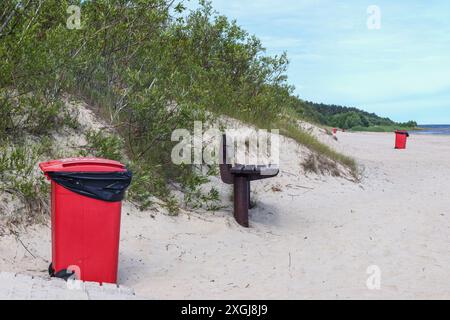 poubelle rouge sur la plage Banque D'Images