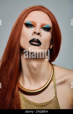 Portrait en gros plan d'une drag queen avec de longs cheveux roux et un maquillage saisissant. Banque D'Images