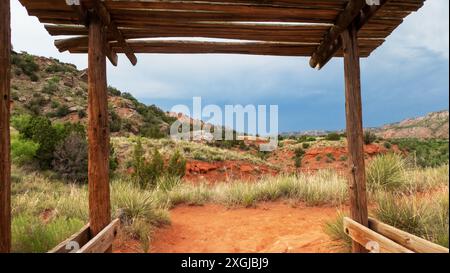 Un auvent partiellement couvert fait de matériaux naturels locaux sur un sentier dans le parc d'État de Palo Duro Canyon, Texas. Banque D'Images