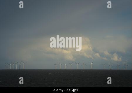 Vue du parc éolien offshore de Gunfleet Sands contre un ciel orageux pris de la rive de Clacton sur la mer, Essex, Royaume-Uni. Banque D'Images