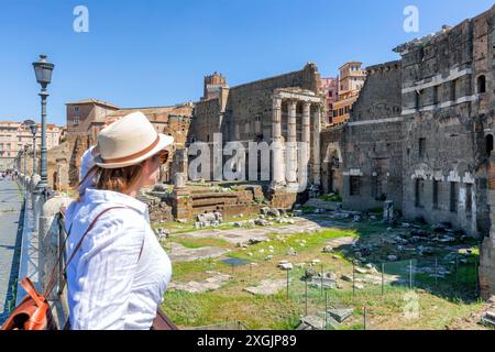 Une heureuse femme blonde touriste se tient près du Forum romain, de vieilles ruines au centre de Rome, en Italie. Concept de voyager monuments célèbres. Banque D'Images