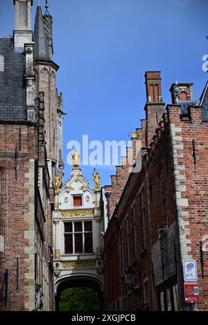Arche ornée de statues d'or au-dessus de Blind Donkey Alley dans la ville de Bruges, Belgique. Banque D'Images