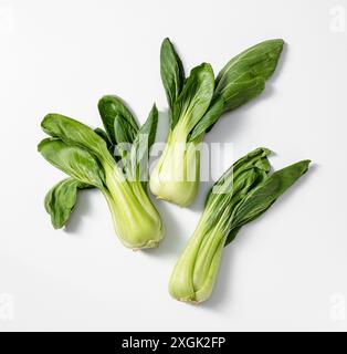 'Vue de dessus de trois têtes fraîches de bok choy avec des feuilles vertes, sur un fond blanc propre. Parfait pour la cuisine, le jardinage et une alimentation saine c Banque D'Images