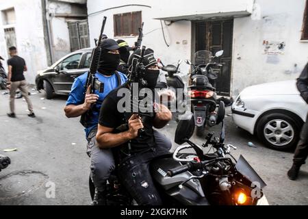 Jénine, Palestine. 06 octobre 2022. Deux Palestiniens armés masqués conduisent une moto lors d'affrontements avec les forces israéliennes qui prennent d'assaut la ville de Djénine, dans le nord de la Cisjordanie. (Photo de Nasser Ishtayeh/SOPA images/Sipa USA) crédit : Sipa USA/Alamy Live News Banque D'Images