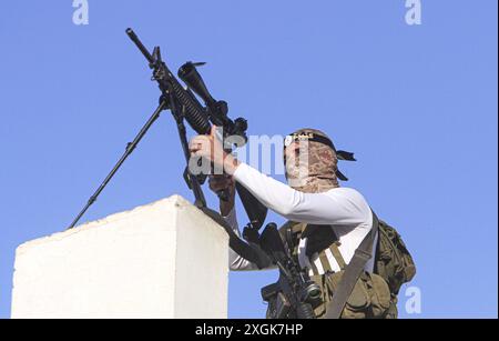 Jénine, Palestine. 06 octobre 2022. Un palestinien armé masqué a été vu visant le toit d'un bâtiment lors d'affrontements avec les forces israéliennes prenant d'assaut la ville de Djénine dans le nord de la Cisjordanie. (Photo de Nasser Ishtayeh/SOPA images/Sipa USA) crédit : Sipa USA/Alamy Live News Banque D'Images