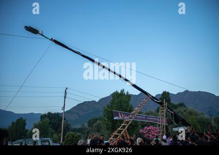 Srinagar, Inde. 09 juillet 2024. Les musulmans chiites du Cachemire tiennent un drapeau islamique installé sur la route de l'estran à Srinagar. Mouharram est le premier mois du calendrier islamique. C'est l'un des mois les plus saints du calendrier islamique. Les musulmans chiites commémorent Mouharram comme un mois de deuil en souvenir du martyre du petit-fils du prophète islamique Mahomet, Imam Hussain, qui a été tué à Ashura (10e jour de Muharram) dans la bataille de Karbala en 680 après J.-C. (photo de Faisal Bashir/SOPA images/Sipa USA) crédit : Sipa USA/Alamy Live News Banque D'Images