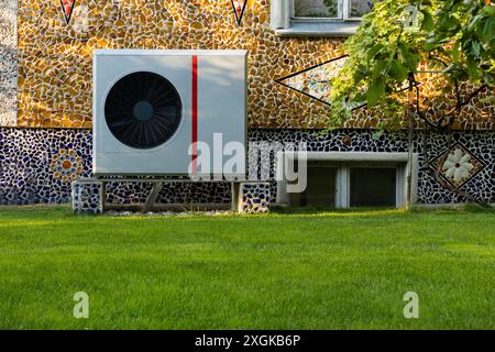 Unité de pompe à chaleur moderne sur des murs en mosaïque colorés Banque D'Images