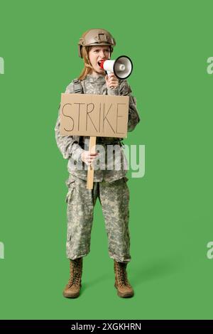 Soldat de protestation tenant une pancarte avec texte FRAPPER et criant en mégaphone sur fond vert Banque D'Images